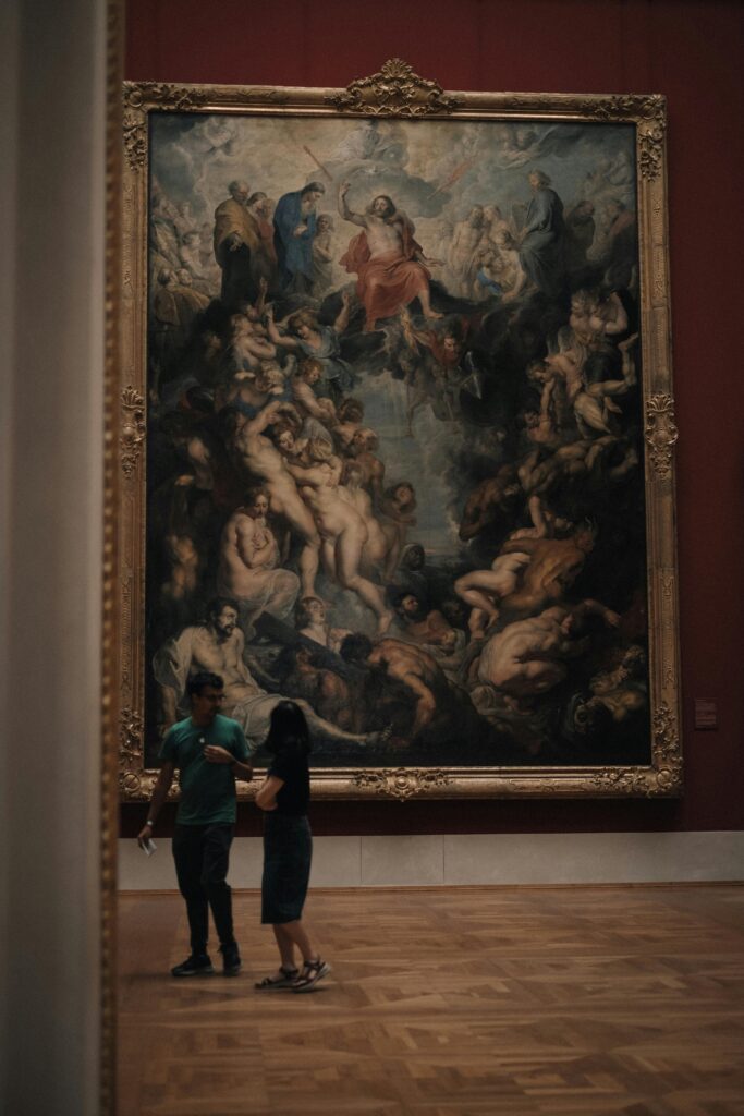 A couple standing and admiring a large oil painting in a Munich museum.